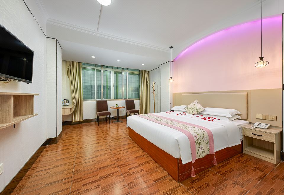 The room features a large bed, white walls, wooden floors, and red accent lighting at Hanqun Hotel (Guangzhou Baiyun International Airport)