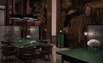 The room is decorated in an art deco style, featuring green walls and black chairs around the table at Andaz Shenzhen Bay
