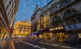 At night, there is an empty road in the middle of a city street, flanked by buildings on both sides at Yitel Premium (Shanghai people's Square Nanjing Road Pedestrian Street)