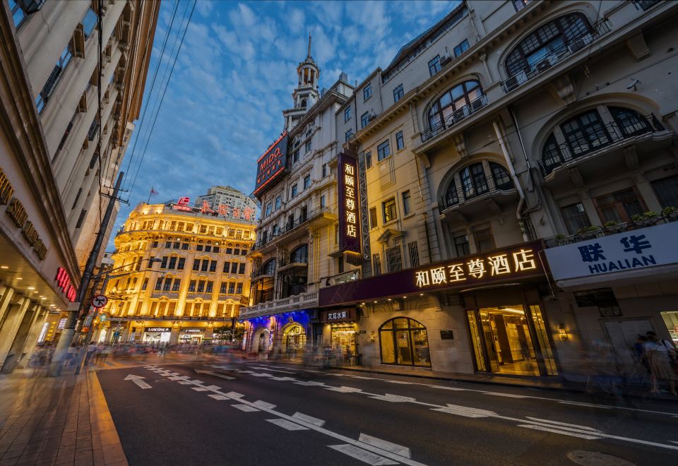 At night, there is an empty road in the middle of a city street, flanked by buildings on both sides at Yitel Premium (Shanghai people's Square Nanjing Road Pedestrian Street shop)