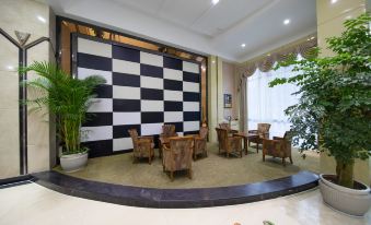 The lobby of the hotel is decorated in an exotic style, featuring large windows, chairs, and tables at Fortune Hotel