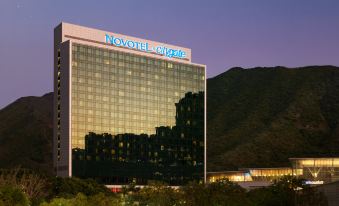 "At night, there is a large building with the word ""hotel"" on it, and there is something in front of it" at Novotel Citygate Hong Kong