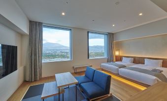 a hotel room with two beds , a couch , and a window overlooking a mountain view at Hotel Clad