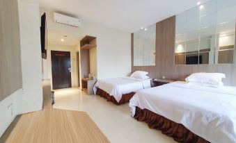 a hotel room with two beds , a television mounted on the wall , and a bathroom at 77 Sunset Plaza