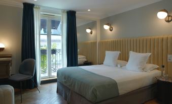 a large bed with white and blue linens is in a room with wooden floors and a sliding glass door at Hotel Bachaumont