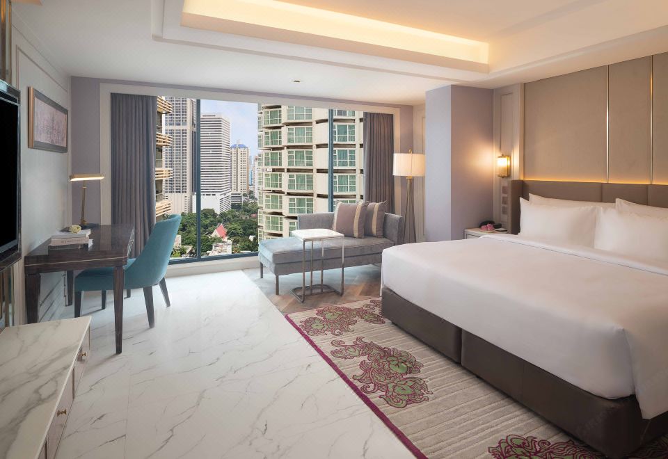 The bedroom features large windows and a balcony with a city view, as well as an elegant bed at Aira Hotel Bangkok Sukhumvit 11