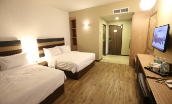 a hotel room with two beds , a desk , and a door leading to an office area at Sem9 Senai "Formerly Known As Perth Hotel"