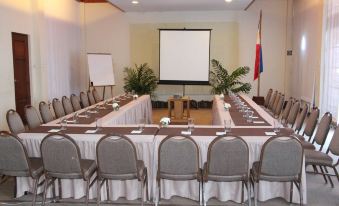 a long table with chairs and a projector screen is set up in a room at Almont Beach Resort