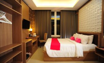 a well - lit hotel room with a large bed , a tv , and a desk , all decorated in a modern style at favehotel Rembang