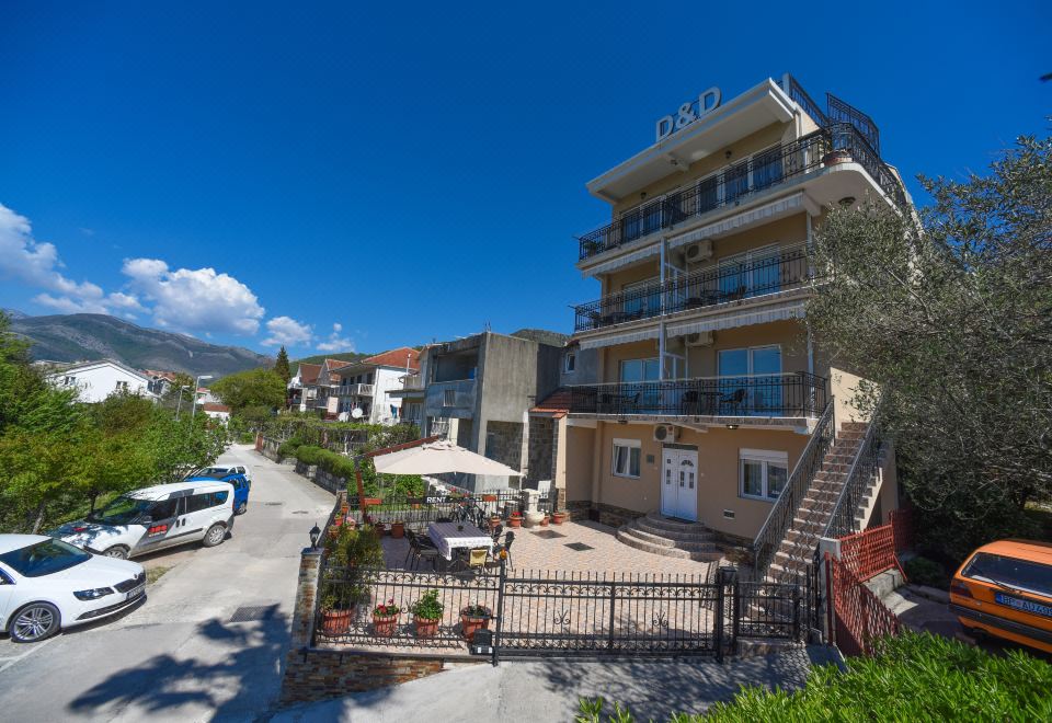 "a large building with a white sign that reads "" casa bella "" is surrounded by a fence and greenery" at D&D Apartments