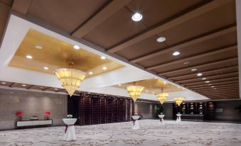 A spacious room with rows of tables in the center and an arched ceiling at Grand Millennium Beijing