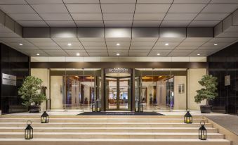 The entrance to a hotel features large windows and doors on both sides, providing access to another area at Radisson Collection Hyland Shanghai
