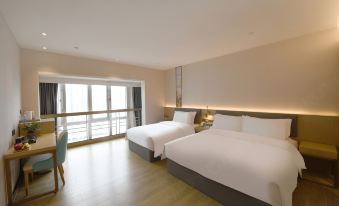 The bedroom features double beds, large windows, and white drapes on the bedspreads at Hangtai Hotel (Shenzhen Science Park Window of the World)