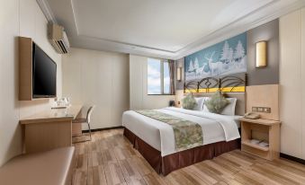 The middle room features a spacious bed, a sitting area, and a window that overlooks other rooms at Discovery Hotel (Guangzhou Railway Station Sanyuanli Subway Station)