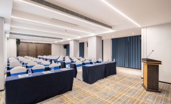 A spacious room with rows of long tables arranged for an event at the hotel at Mehood Lestie Hotel (Maoming High-speed Railway Station)