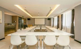 A spacious conference room is available for meetings or special events, furnished with white tables and chairs at Jinjiang Inn(Beijing Tongzhou Beiyuan Subway Station)