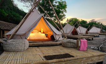 a group of tents set up on a wooden platform , with a bed inside the tents at Bluewater Sumilon Island Resort