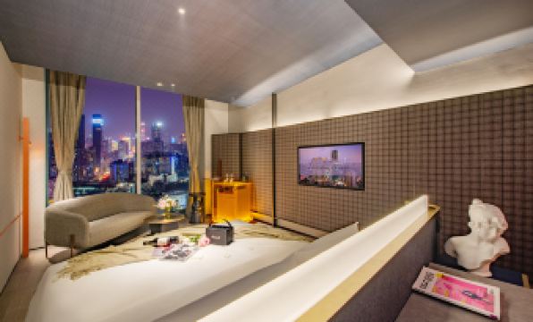 The room features large windows and an attached bathroom, both decorated in the same color at Grade Hotel Shenzhen sea world