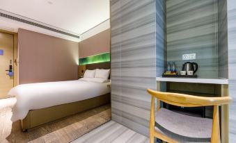 There is a bed and a table in the bedroom of a hotel with double beds, positioned next to each other at Hanting Youjia Hotel (Shanghai East Nanjing Road Branch)
