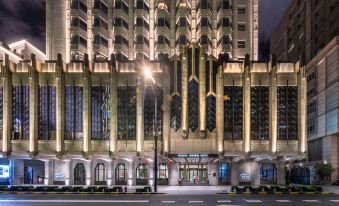 The illuminated front entrance of a hotel at night, offering a view from outside at Elegant Hotel Shanghai Bund