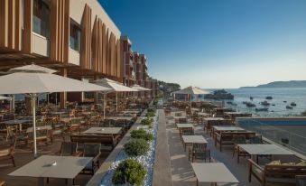 an outdoor dining area with numerous tables and chairs set up for guests to enjoy a meal at Maestral Resort & Casino