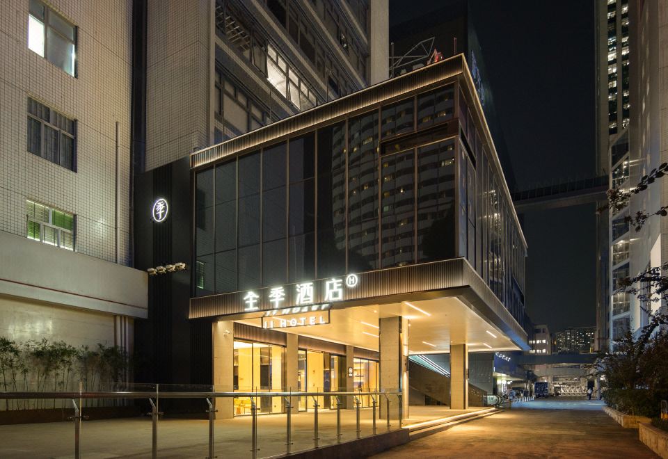 At night, a hotel entrance is adorned with an illuminated sign above its glass door at All Seasons Hotel (Shenzhen Huaqiang North Electronic Building Shop)