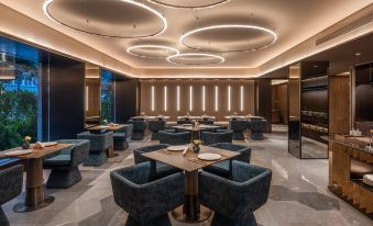 The restaurant is illuminated by overhead lighting and features spacious tables and chairs at Crystal Orange Beijing Shangdi Zhongguancun Software Park Hotel