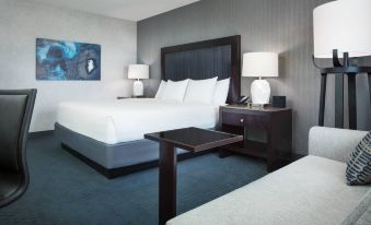 a modern hotel room with a white bed , black headboard , and matching nightstands , along with some nightstands and lamps at Hyatt Regency San Francisco Airport