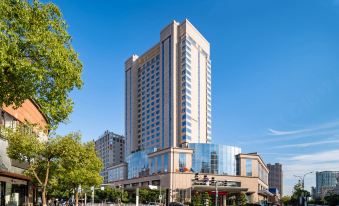 There is a large building with a visible name on its front side, offering an outside view at New Joyful Hotel