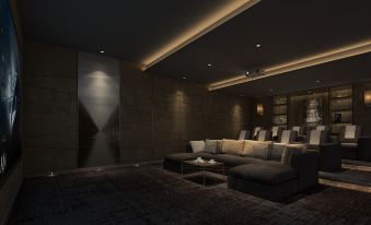 a modern living room with dark walls , a couch , and a tv , illuminated by ceiling lights at Somerset Grand Central Dalian