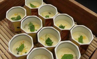 a dining table with a variety of bowls filled with various types of food , including soup and other dishes at Hotel Hokke Club Hiroshima