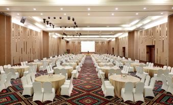 a large banquet hall with rows of tables and chairs , all set up for a formal event at Aston Kupang Hotel & Convention Center