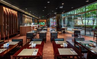 The restaurant is equipped with tables, chairs, and other dining room furniture at Grand Millennium Beijing