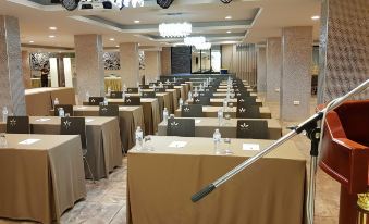 a conference room with rows of tables and chairs , each table has a microphone on it at Soho Boutique Hotel