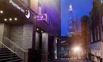 "a building with a sign that says "" premier inn "" is lit up at night , with a tall building in the background" at Premier Inn Honiton