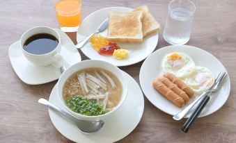 a table is set with a variety of breakfast items , including a bowl of soup , an egg , and toast at Baan Kieng Tawan