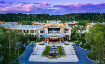 an aerial view of a large , modern building with a fountain in front of it at Pullman Changbaishan Resort
