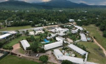 aerial view of a residential area with multiple buildings and a pool surrounded by trees at Mission Beach Resort