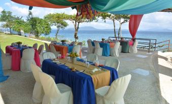 a beautifully decorated dining table set up for a special event , with multiple chairs arranged around it at Almont Beach Resort