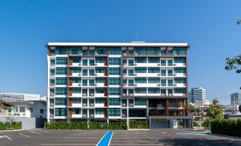 A large building with balconies on the side and an apartment at one end at Orion Hotel & Residence Bangna