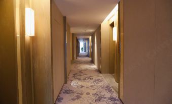 In this modern-style hotel, there is a long hallway with carpeted floors and doors leading to other rooms at LEFUQIANG BOYUE HOTEL