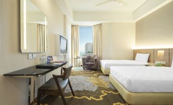 a modern hotel room with two beds , a desk , and a large window offering a view of the city at Cititel Penang