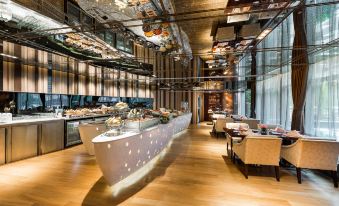 The restaurant in the center has tables and chairs, as well as floor-to-ceiling windows at Pullman Guangzhou Baiyun Airport