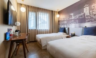 The bedroom features double beds and a large window that overlooks a table with a bedspread on top at Super 8 Hotel Premier (Beijing Workers' Stadium Sanlitun Chunxiu Road)