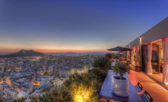 a beautiful view of a city at dusk , with a restaurant on a hill overlooking the skyline at President Hotel