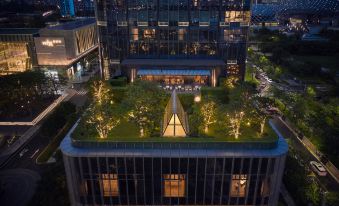 The view from a rooftop at night, with an illuminated building in front and another skyscraper in the background, is breathtaking at Andaz Shenzhen Bay