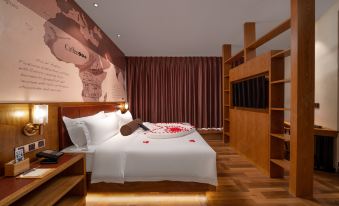The modern bedroom features large windows and an orange accent wall behind the double bed at James Joyce Coffetel Hotel (Guangzhou Beijing Road Metro Station Pedestrian Street)