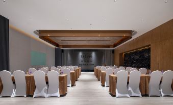 A spacious room at the hotel or conference venue is arranged with rows of chairs for an event at UrCove by HYATT Nanjing South Railway Station