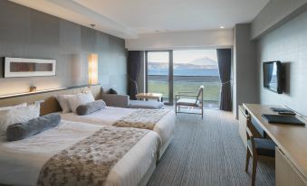 a hotel room with two beds , one on the left and one on the right side of the room at The Lake View Toya Nonokaze Resort