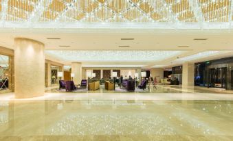 In the middle of the lobby, there are chairs and tables, adjacent to an ornate ceiling at Boyue Hotel Shanghai Air China Hongqiao Airport